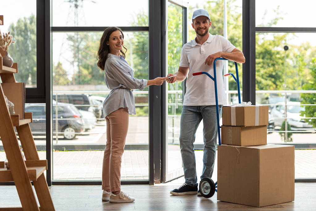 селективный фокус доставки мужчина стоит рядом с корзиной с коробками и женщина с цифровым планшетом
  - Фото, изображение