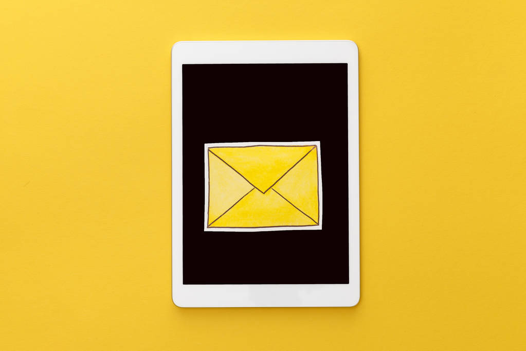 sarı arka planda boş ekranlı dijital tablette harfin üst görünümü - Fotoğraf, Görsel
