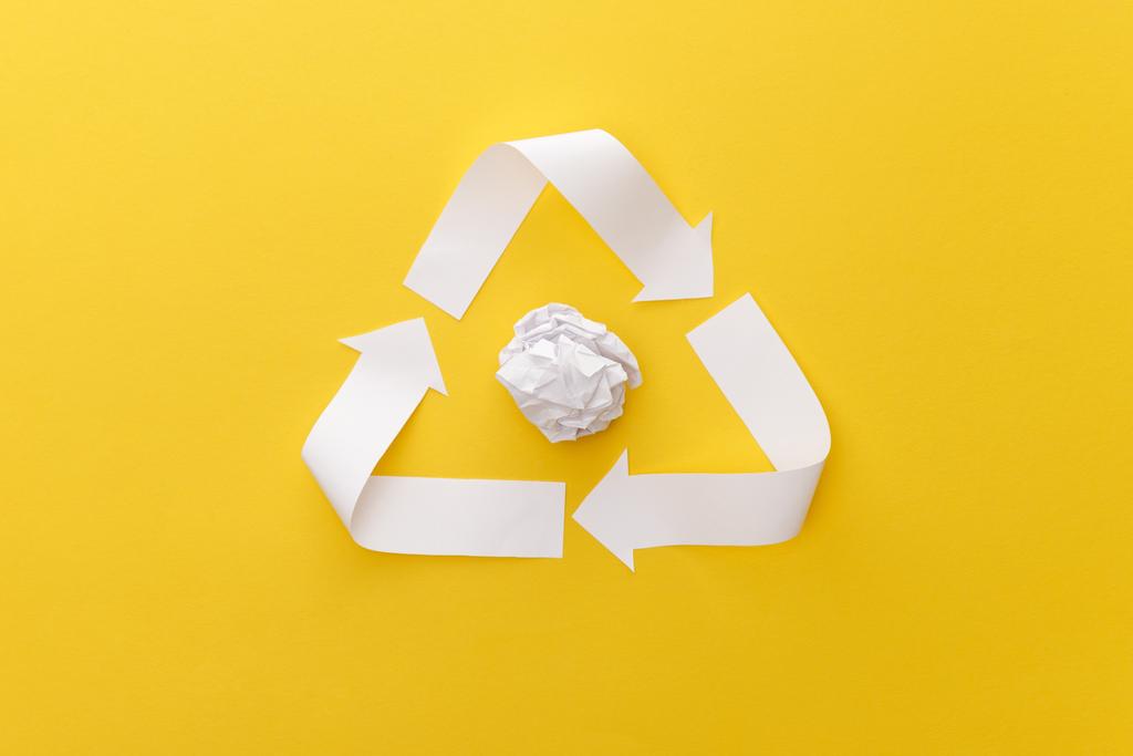 top view of white triangle with crumpled paper on yellow background - Photo, Image