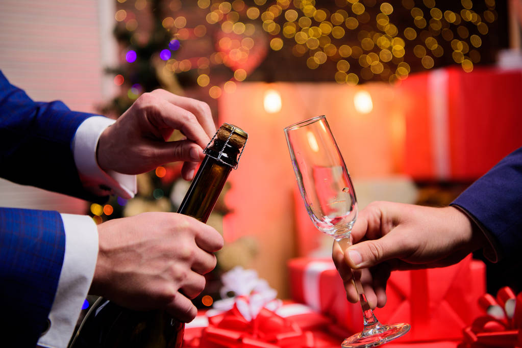 Ünnepeld az új évet pezsgővel. Utolsó pillanatban, mielőtt új évet. Újévi visszaszámlálás. Hands nyitó pezsgőüveg és tartsuk üveg karácsonyi díszek háttér. Igyál pezsgőt vagy pezsgőbort - Fotó, kép