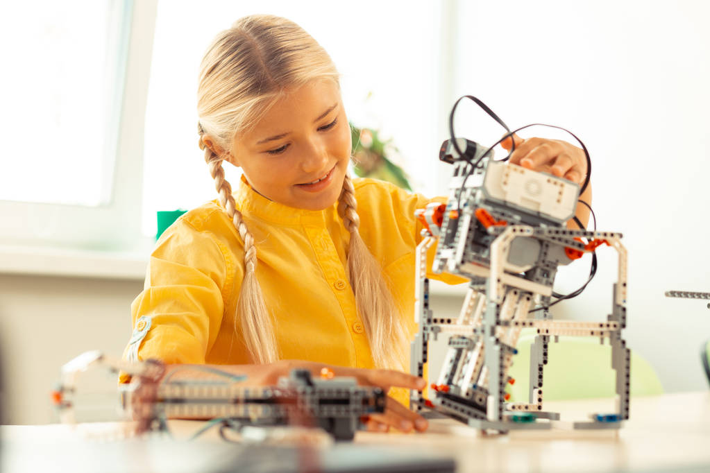 Девушка играет с роботом на уроке
. - Фото, изображение