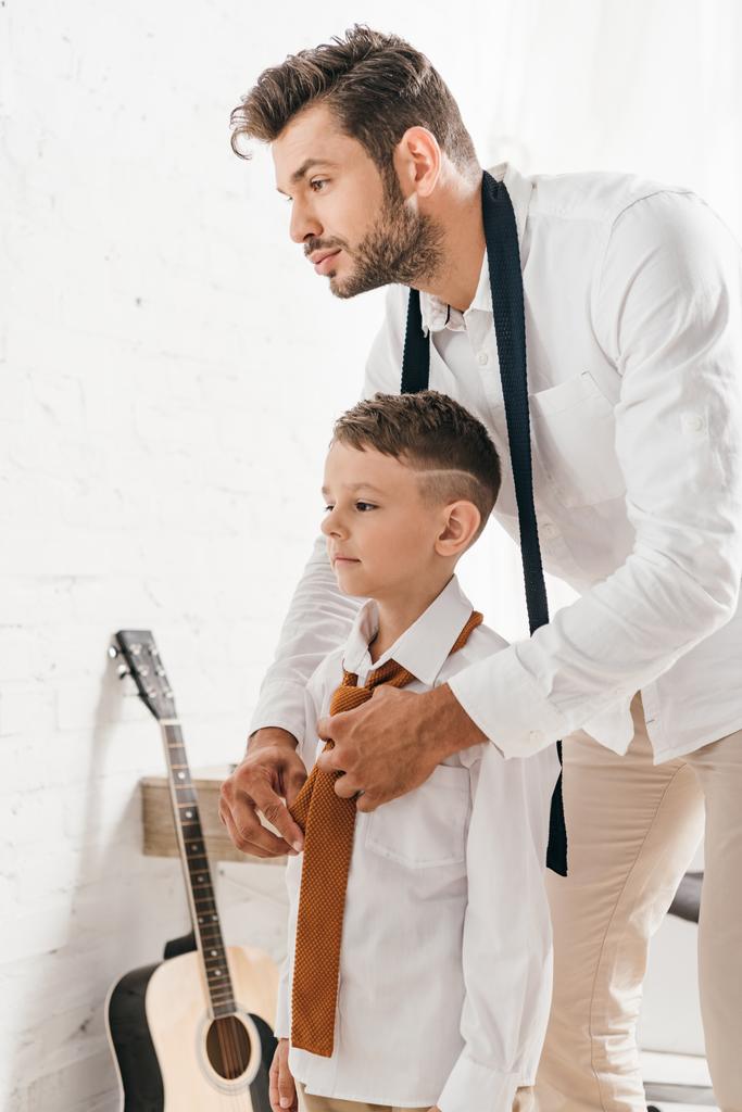 Brodaty tata pomaga synowi z krawatem w domu - Zdjęcie, obraz