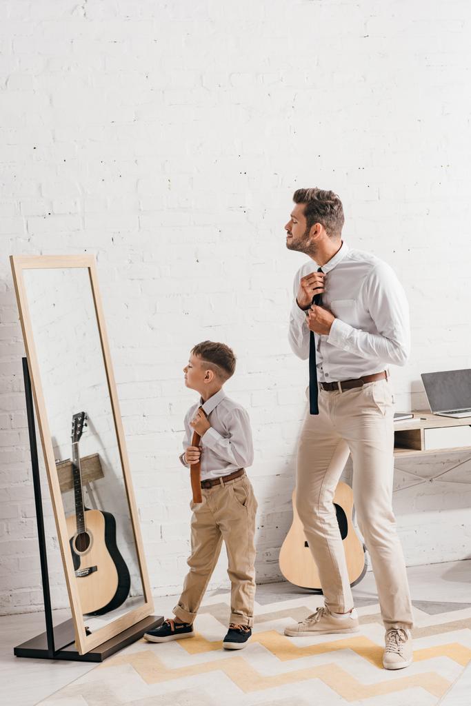 full length view of son and father in formal wear standing near mirror - Photo, Image