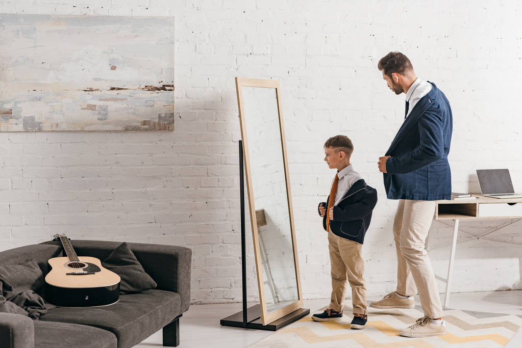 повнометражний вид батька і тата в офіційному одязі, що стоїть біля дзеркала вдома
 - Фото, зображення