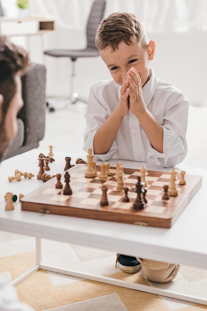 cropped view of dad and son playing chess together at home - Photo, Image