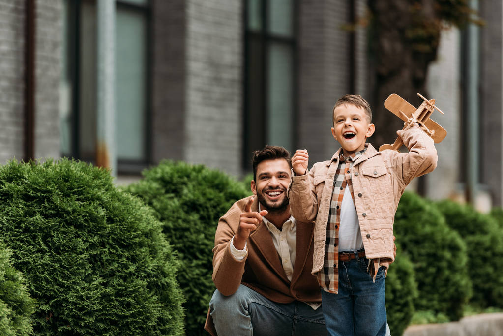 felice barbuto padre e figlio con aereo giocattolo sorridente sulla strada
 - Foto, immagini