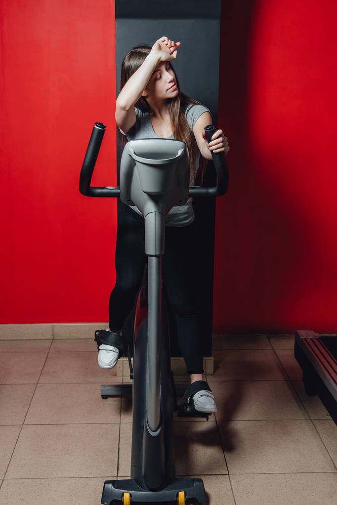 Упражнение на велосипеде кардио тренировки в тренажерном зале женщина, принимая машину потери веса с аэробной для тонкого и твердого здорового утра
. - Фото, изображение