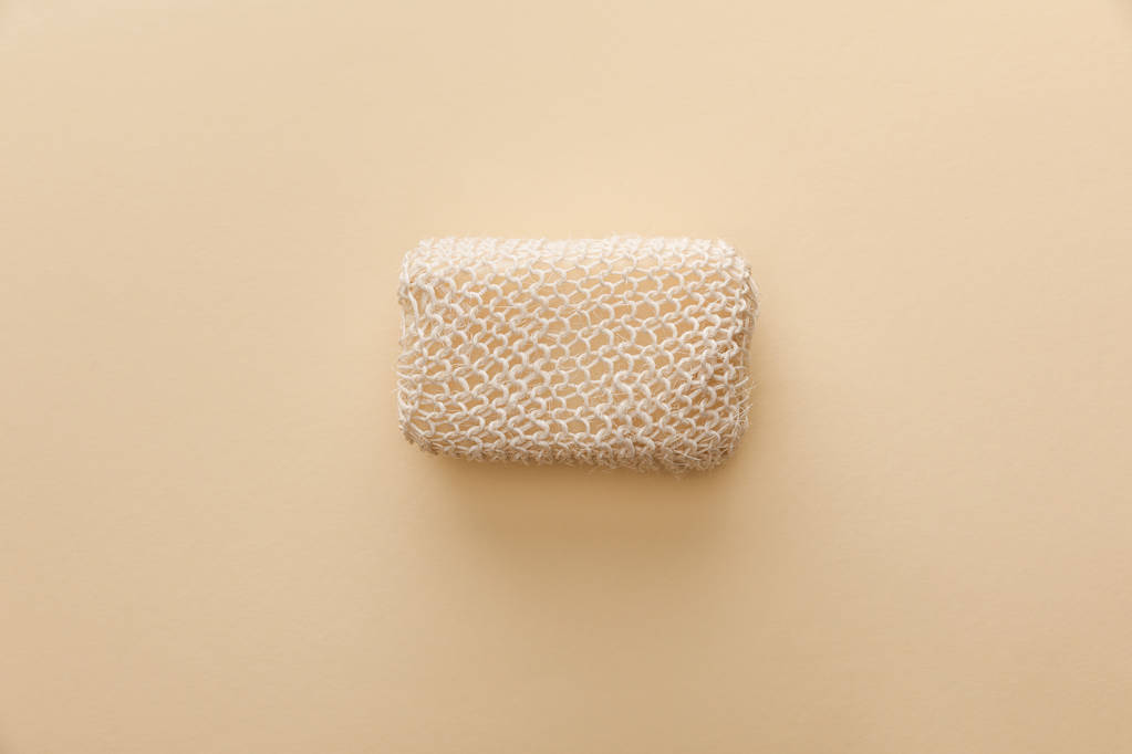 vista superior de la esponja de baño natural sobre fondo beige
 - Foto, imagen