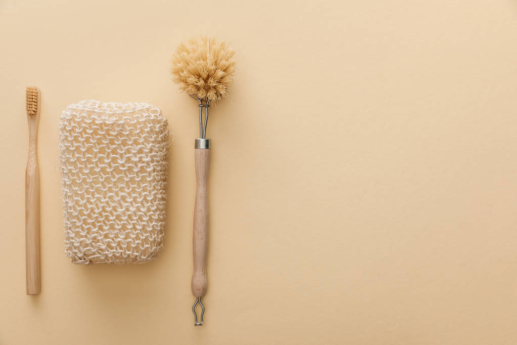 top view of natural bath sponge near toothbrush and body brush on beige background - Photo, Image