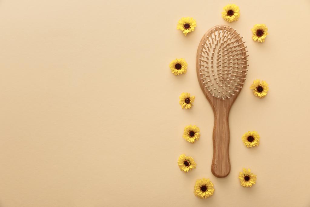 ylhäältä näkymä puinen hiusharja beige taustalla kukkia
 - Valokuva, kuva
