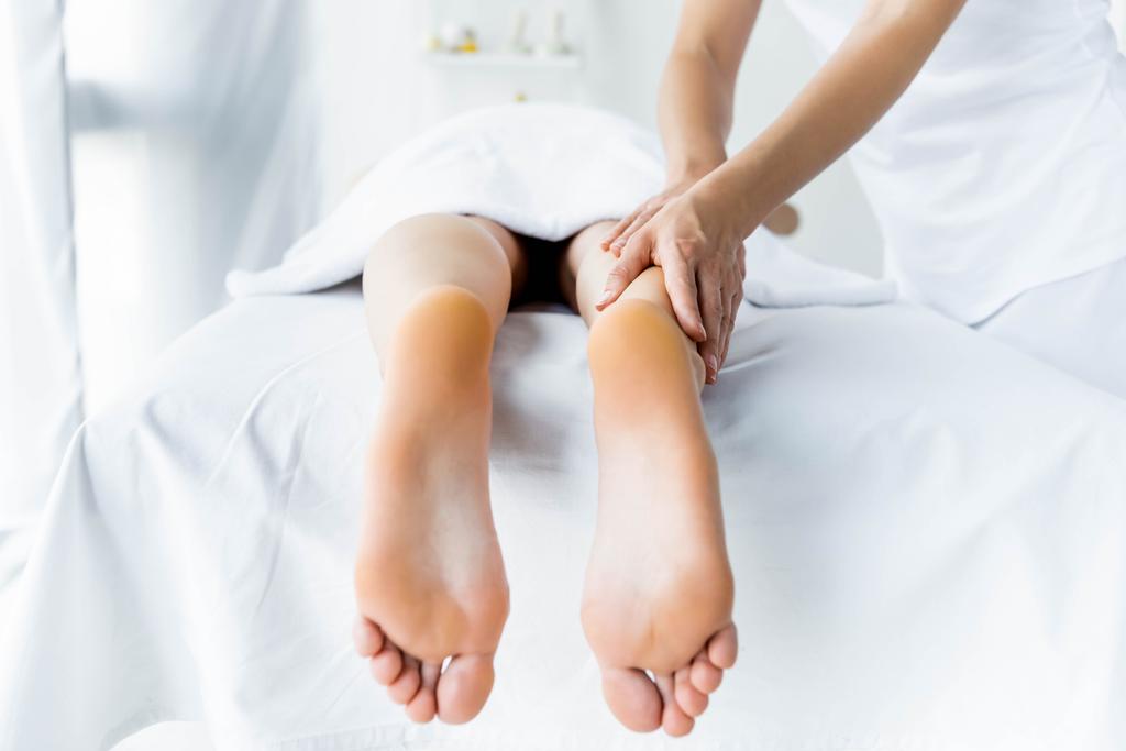vista cortada de massagista fazendo massagem nos pés para a mulher no spa
  - Foto, Imagem