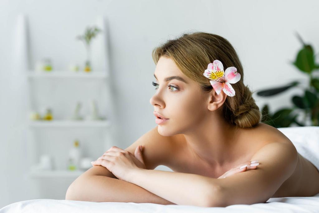 mulher atraente com flor deitada no tapete de massagem no spa
  - Foto, Imagem
