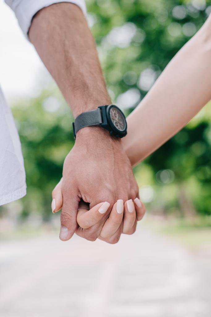 Ausgeschnittene Ansicht von Mann und Frau beim Händchenhalten - Foto, Bild