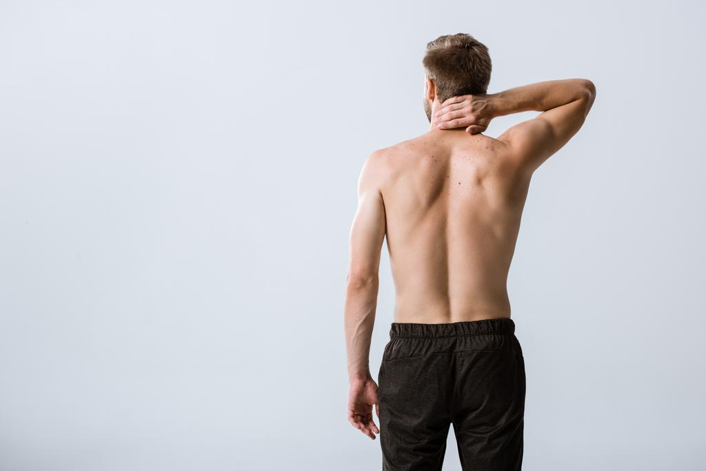 πίσω όψη του χωρίς γυμνό άνθρωπο με πόνο στο λαιμό απομονωθεί σε γκρι - Φωτογραφία, εικόνα