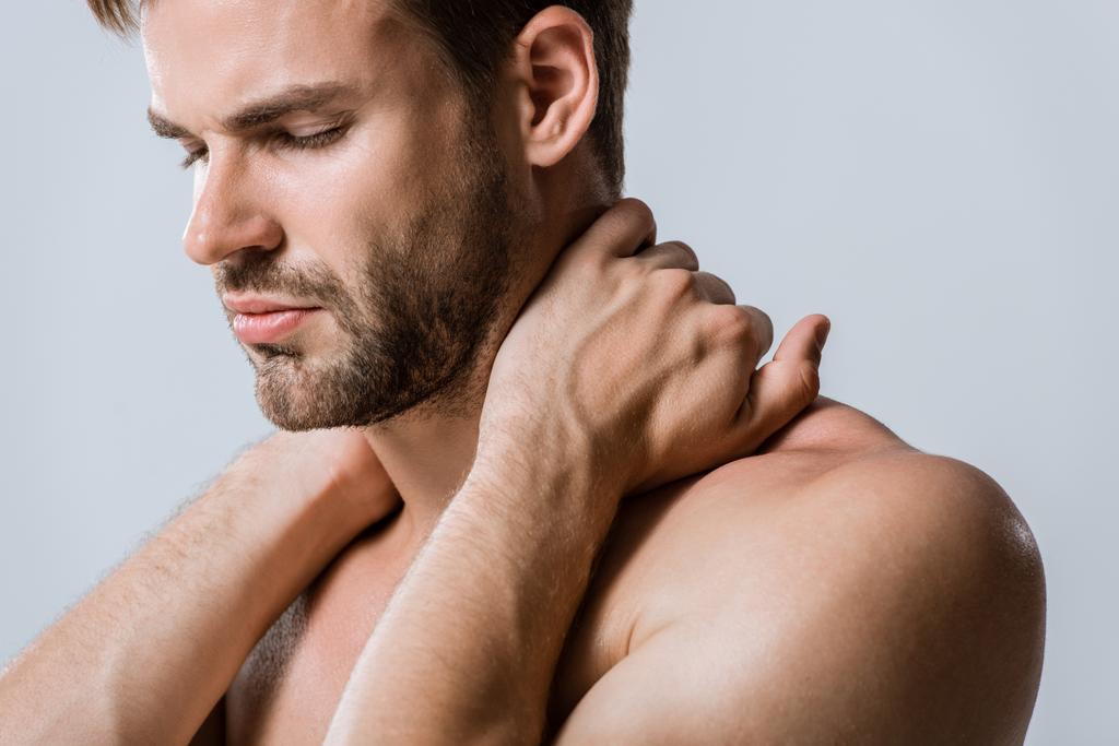 Hemdloser bärtiger Sportler mit Nackenschmerzen isoliert auf grau - Foto, Bild