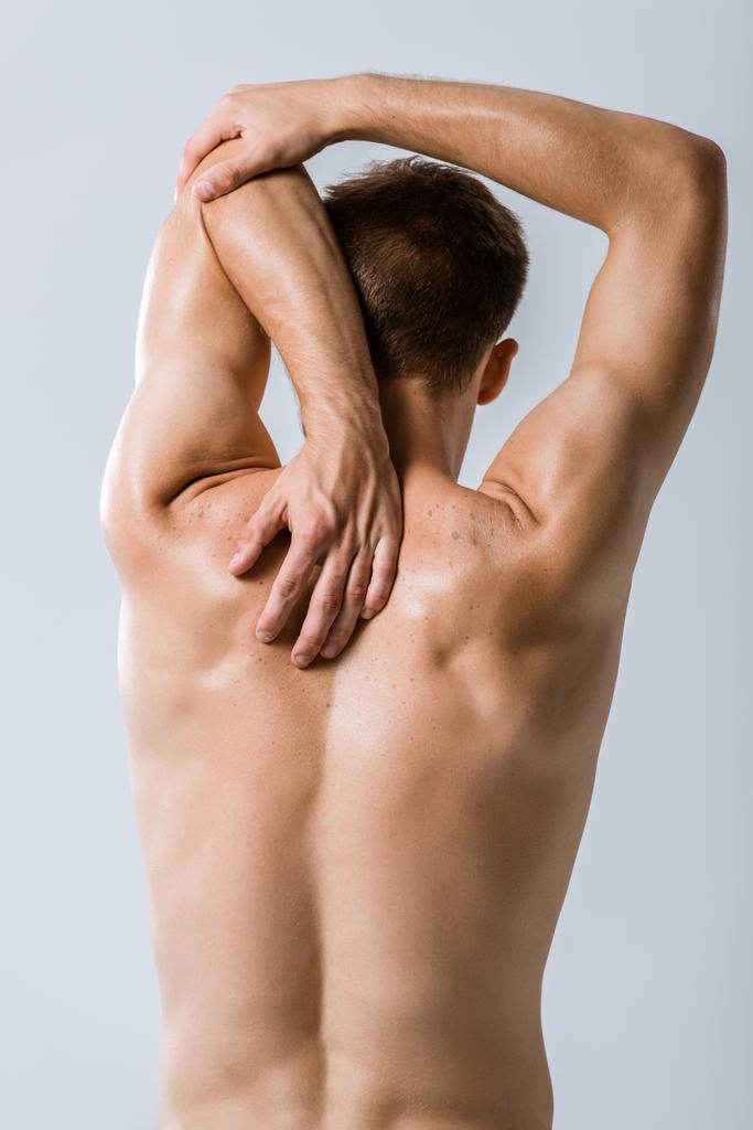 back view of shirtless sportsman stretching isolated on grey - Photo, Image