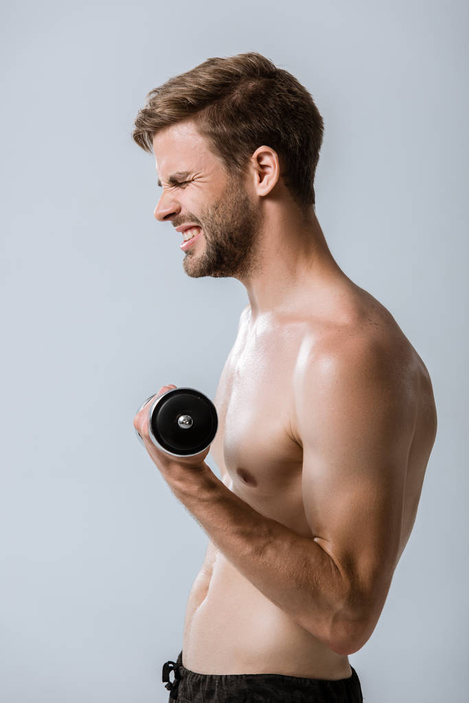 side view of shirtless sportsman using barbell isolated on grey - Photo, Image