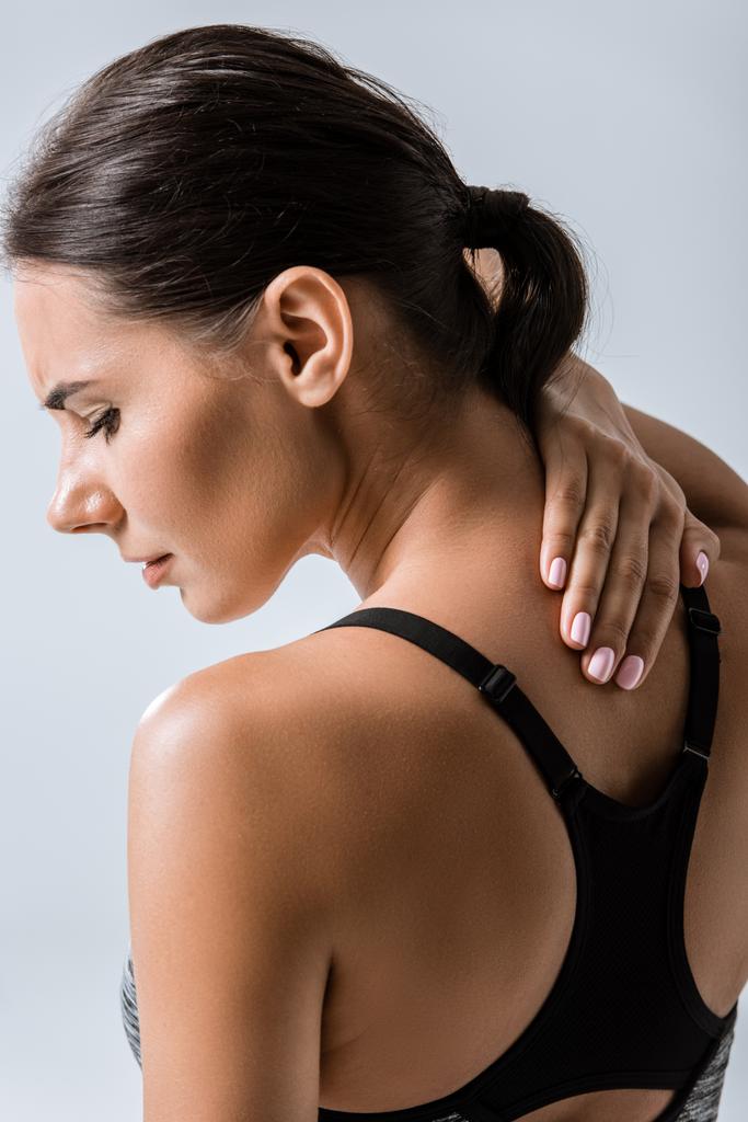 attractive sportswoman with neck pain isolated on grey - Photo, Image