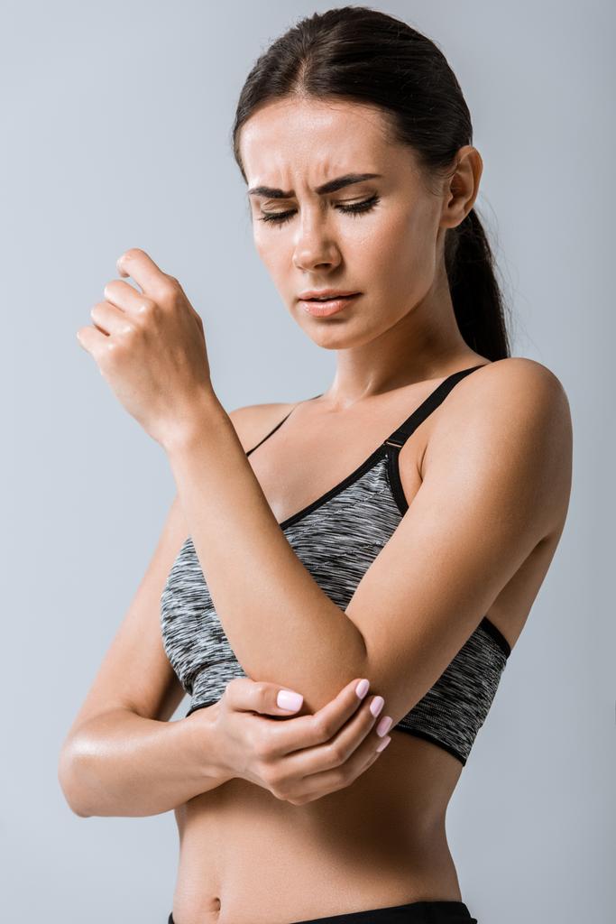 приваблива спортсменка з ліктем болю ізольована на сірому
 - Фото, зображення