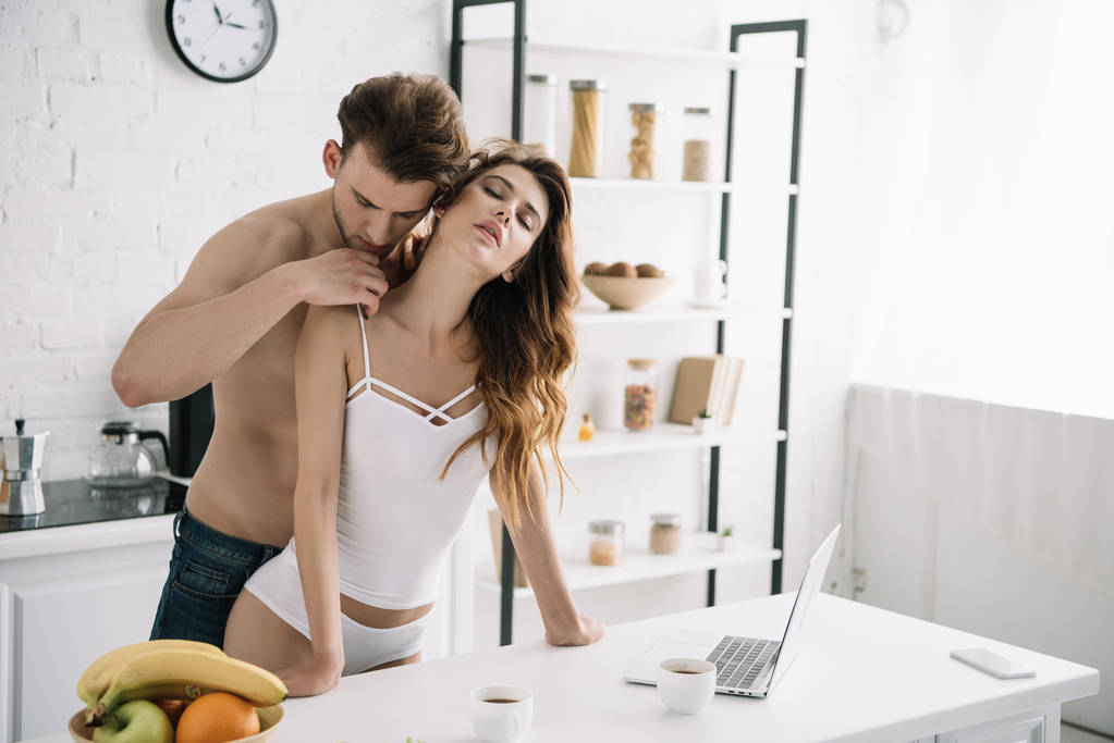 attractive girlfriend with closed eyes and handsome boyfriend hugging in apartment  - Photo, Image