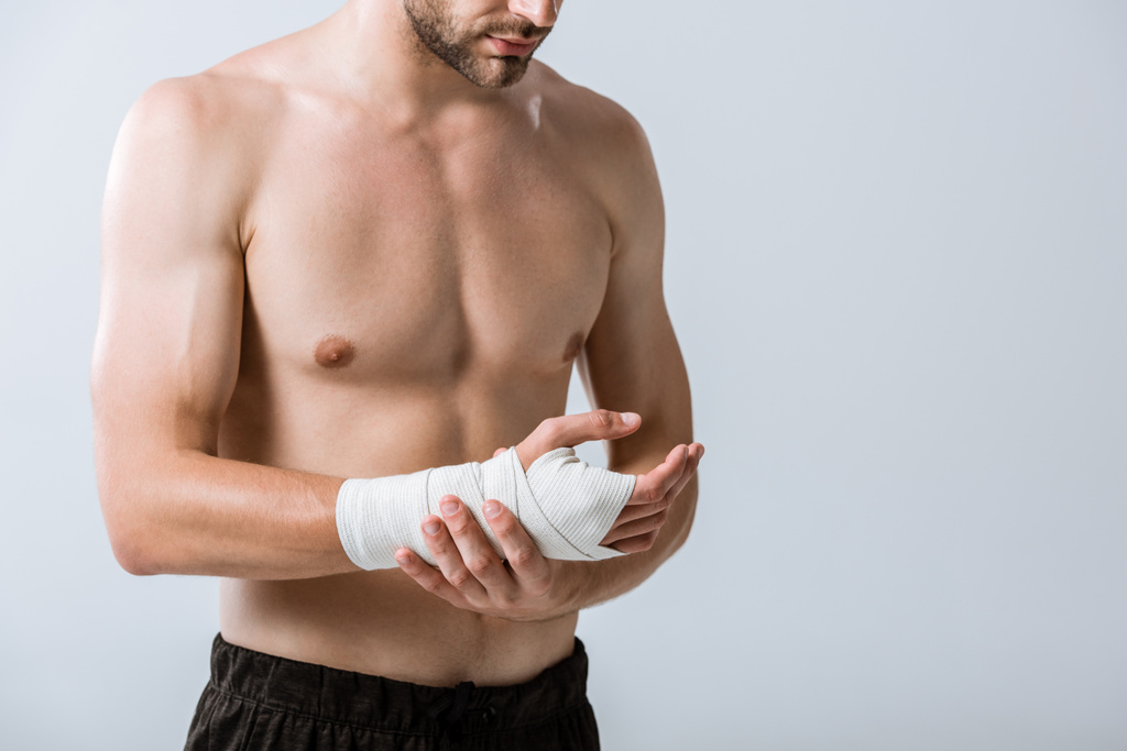vue recadrée du sportif torse nu avec bandage élastique au poignet isolé sur gris
 - Photo, image