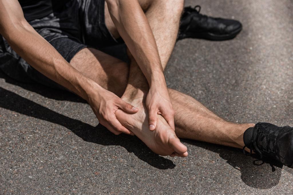 partial view of barefoot sportsman with foot pain on street - Photo, Image