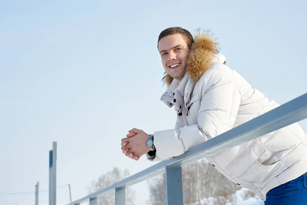 Moda piękny portret młodego człowieka piękne w białą kurtkę z kapturem futro zimą - Zdjęcie, obraz