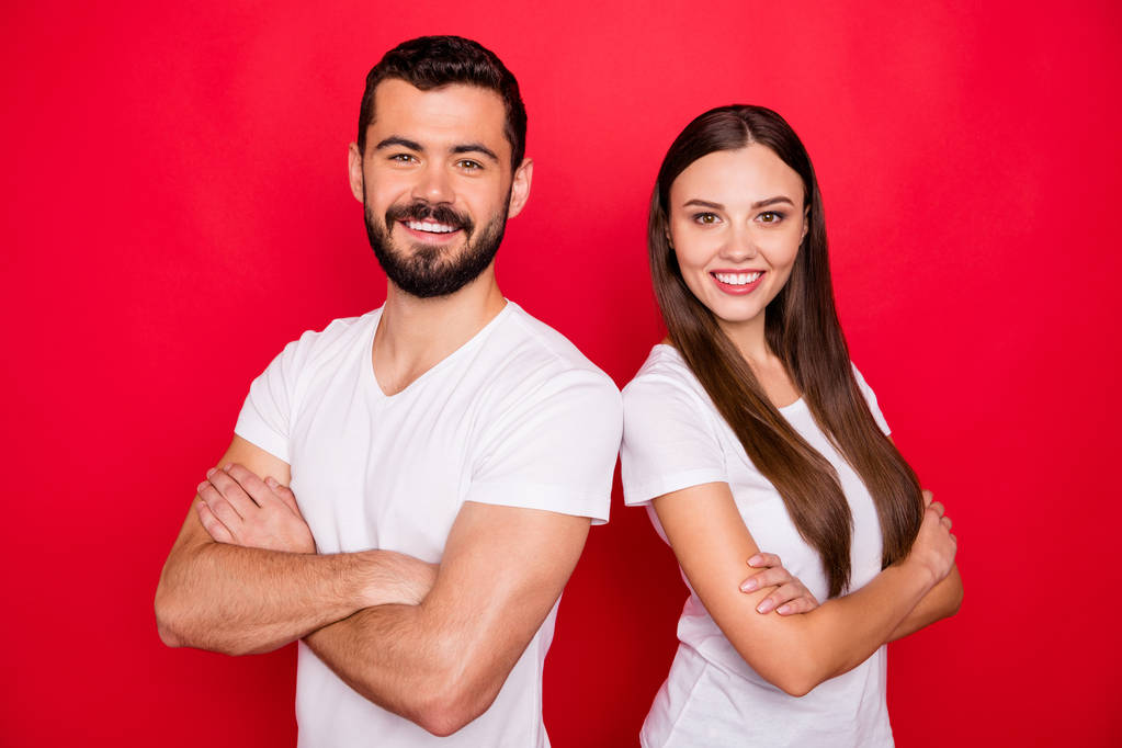 Photo de mignon joli couple branché de deux personnes debout dos à dos tandis que isolé avec fond rouge portant t-shirt blanc à la mode
 - Photo, image