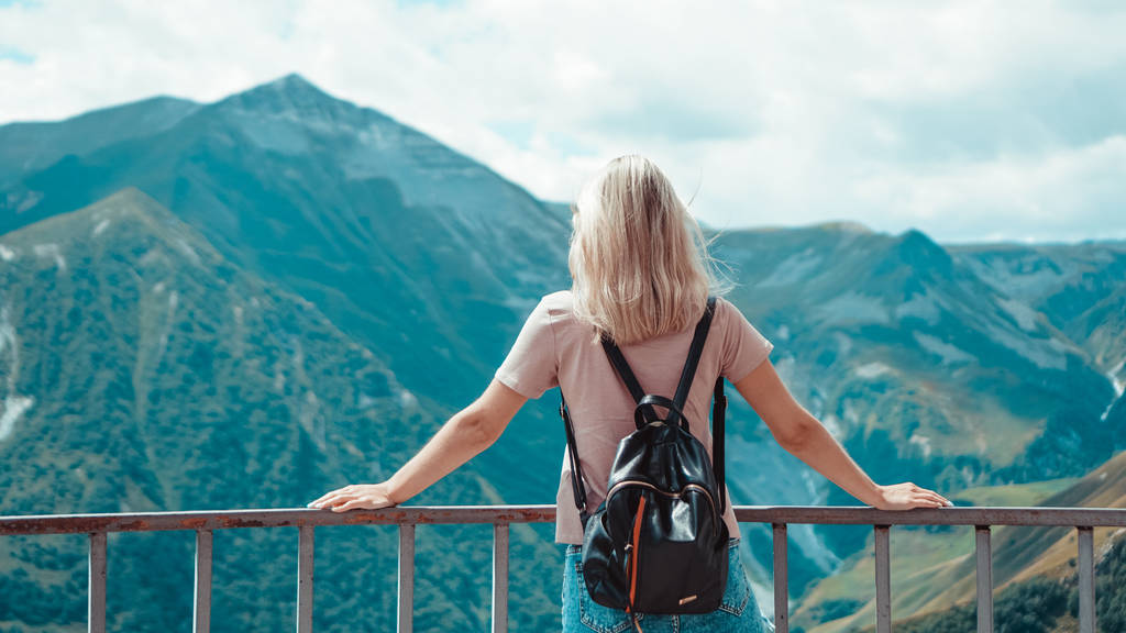 Woman hiking in mountains at sunny day time - Photo, Image