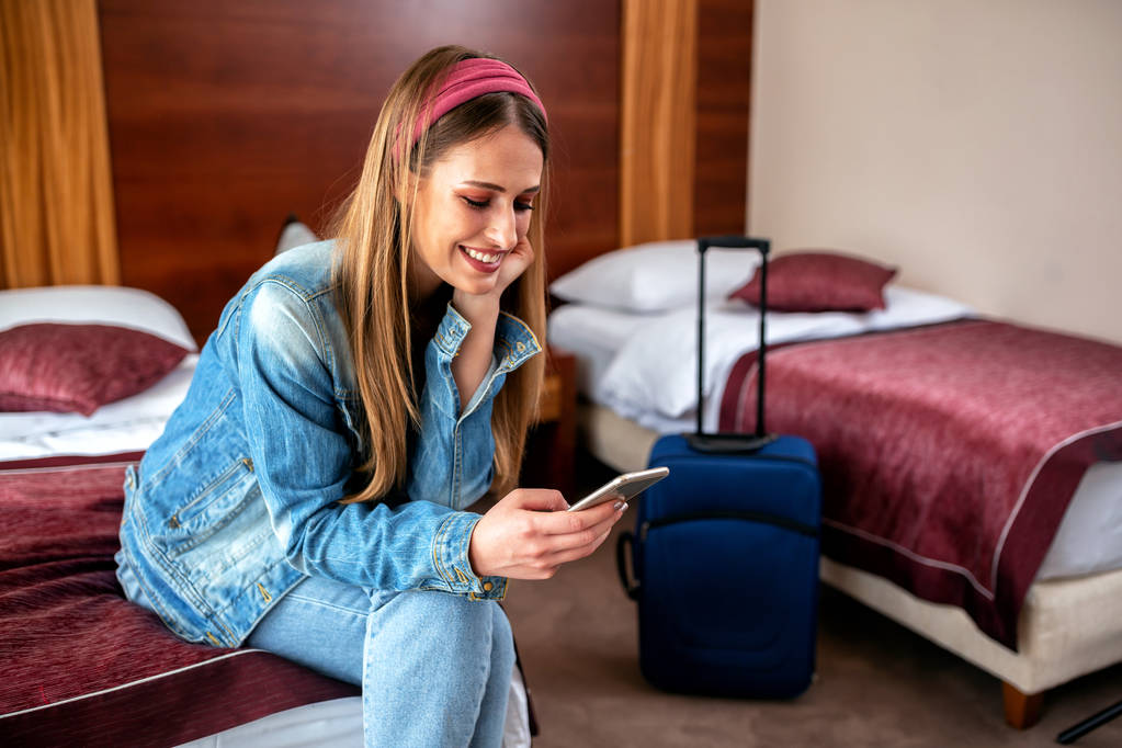 Ονειρεμένη κοπέλα που διασκεδάζει σε ένα δωμάτιο ξενοδοχείου - Φωτογραφία, εικόνα