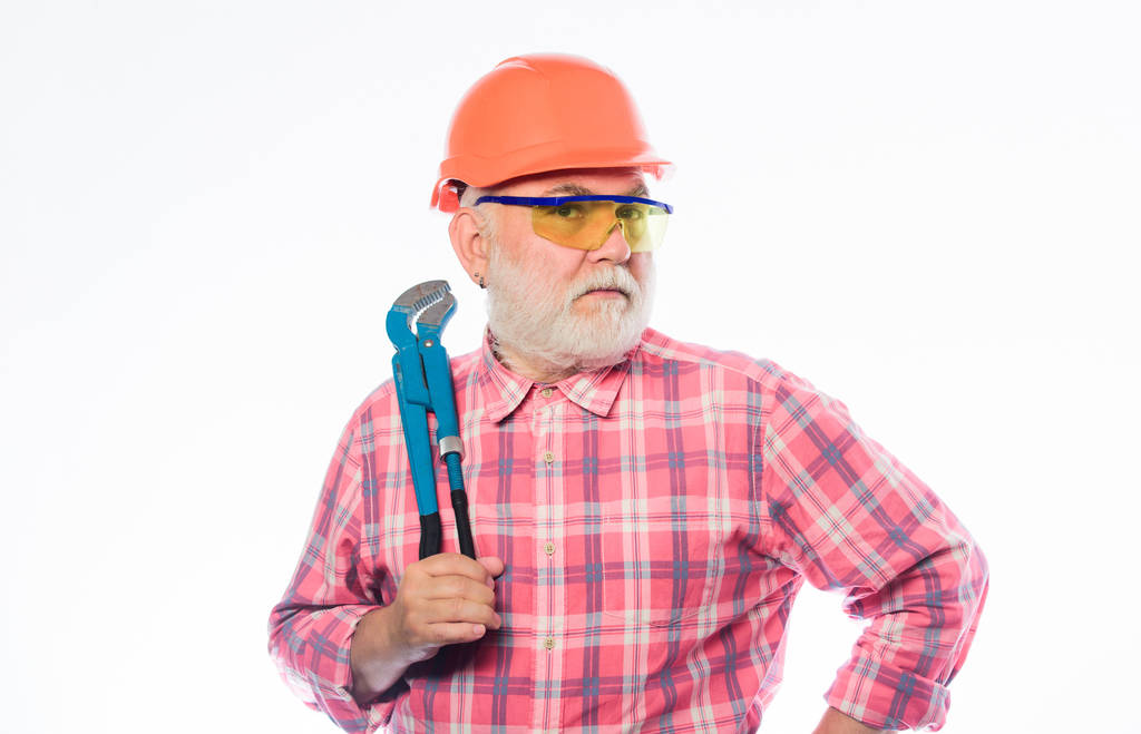professional repairman in helmet with gas wrench. build and construction. architect repair and fix. engineer worker. mature bearded man in hardhat. man builder with adjustable pipe wrench - Photo, Image