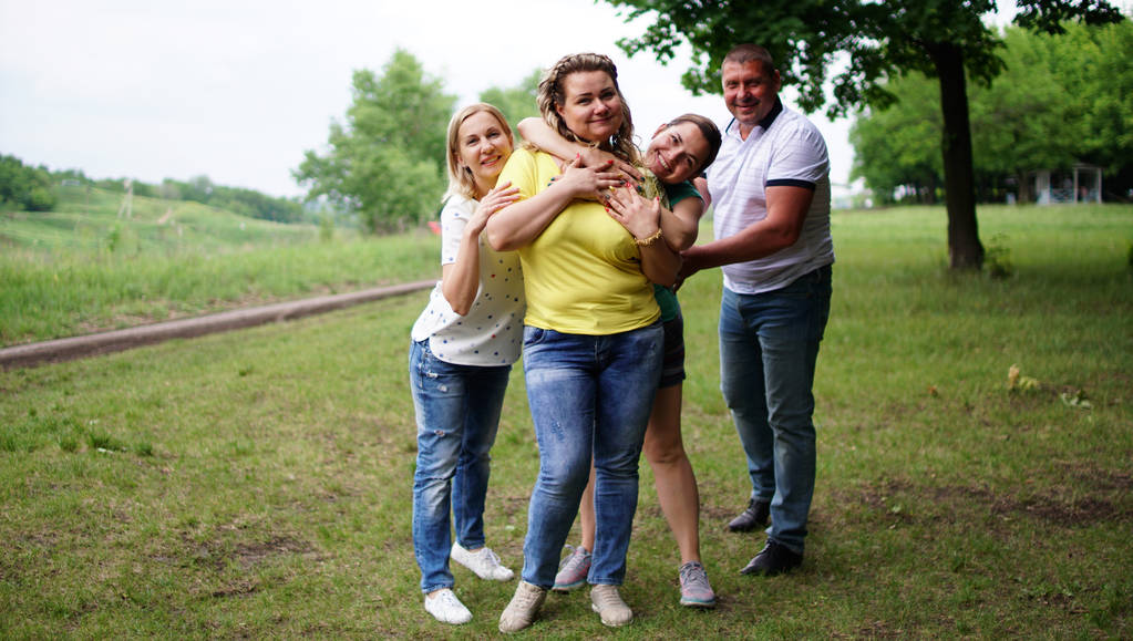 Cute middle aged group embracing one another outdoors in a park - Photo, Image