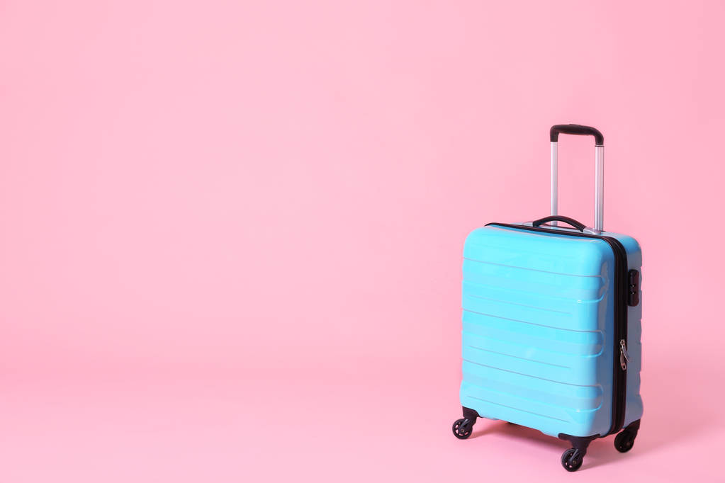 Современный синий чемодан на светло-розовом фоне. Пространство для текста
 - Фото, изображение