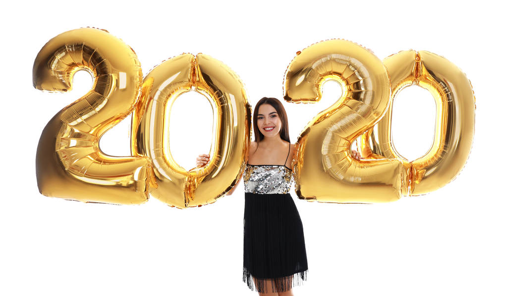Szczęśliwa młoda kobieta ze złotymi 2020 balonów na białym tle. Uroczystość Sylwestrowa - Zdjęcie, obraz