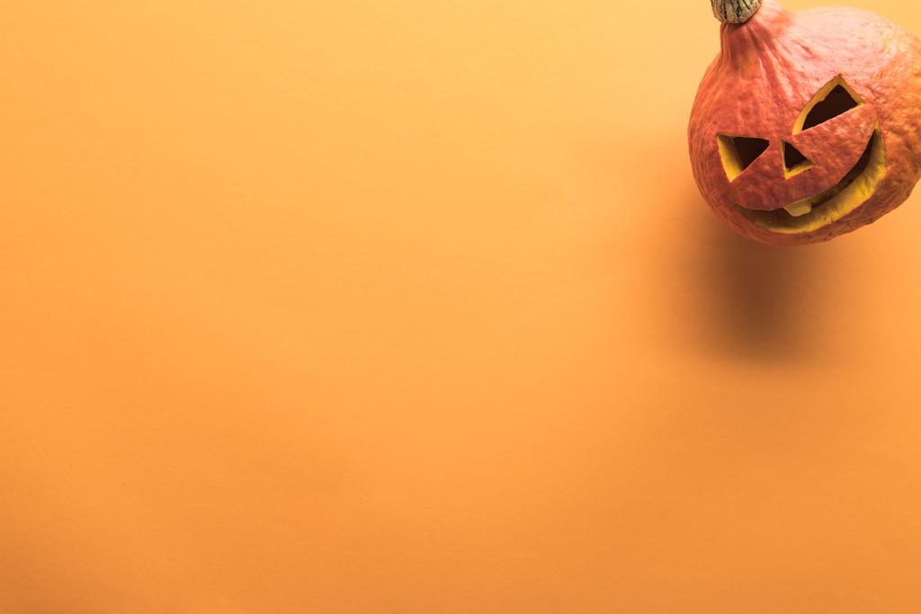 Widok z góry rzeźbione Halloween dyni na pomarańczowym tle - Zdjęcie, obraz