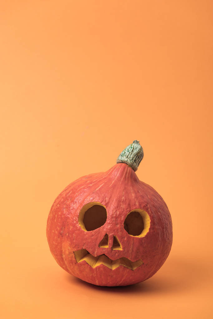 spooky carved Halloween pumpkin on orange background - Photo, Image
