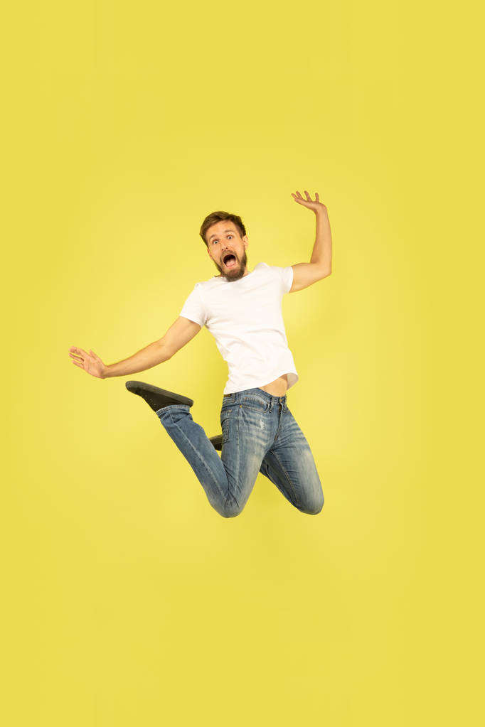 Pełna długość portret szczęśliwy skoki człowiek na żółtym tle - Zdjęcie, obraz