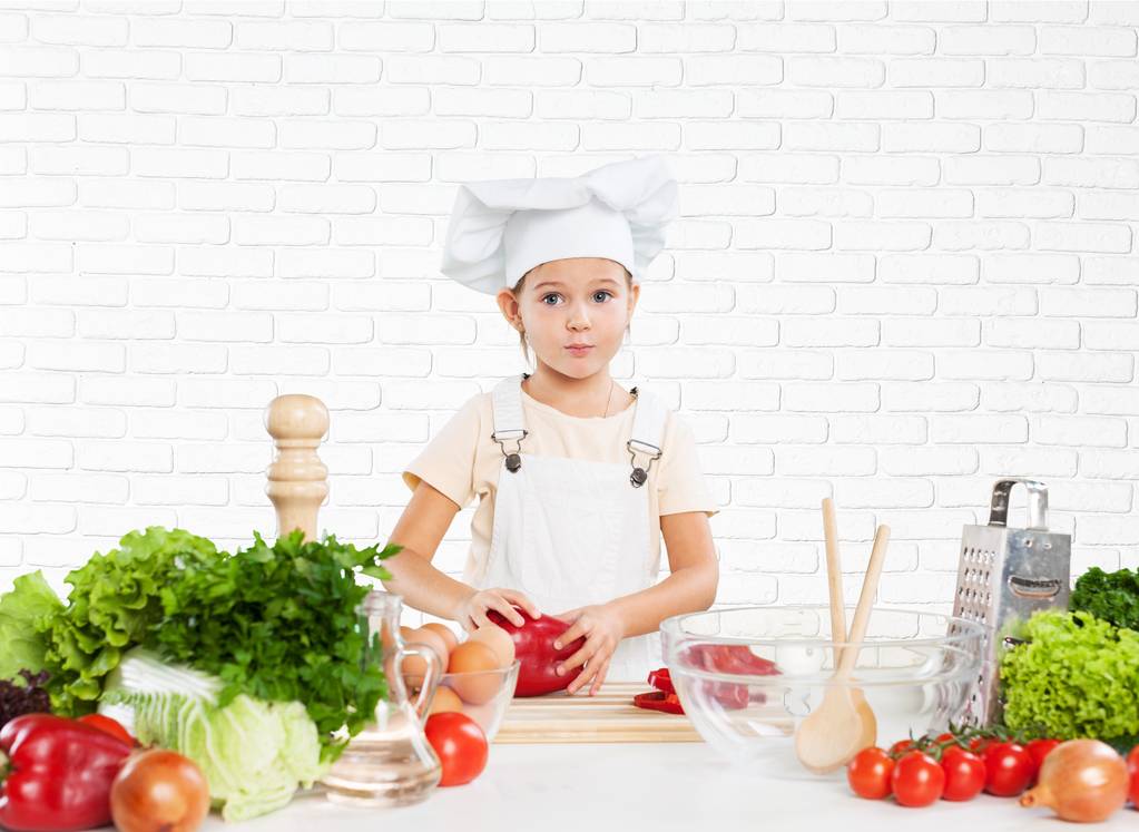 bambina in cucina in cappello da chef
  - Foto, immagini