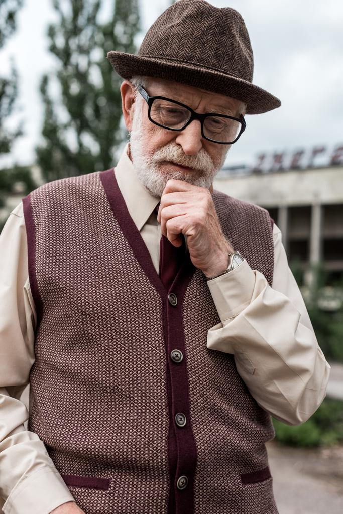 пенсионер, стоящий возле здания в Чернобыле
  - Фото, изображение