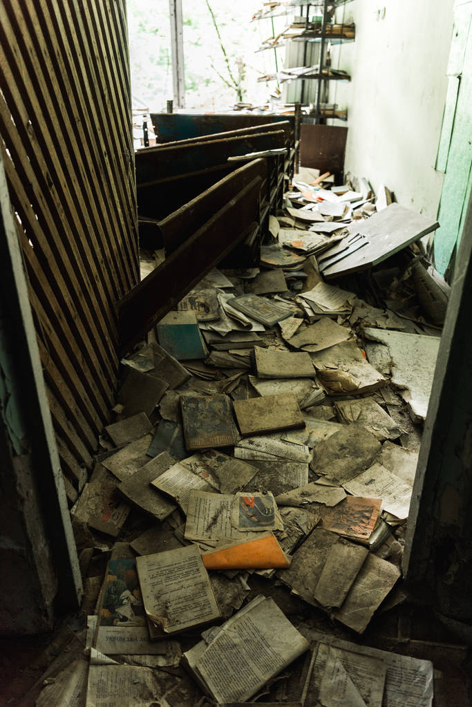 PRIPYAT, UKRAINE - 15 AOÛT 2019 : salle de classe sale et abandonnée avec des livres sur le sol à l'école
  - Photo, image