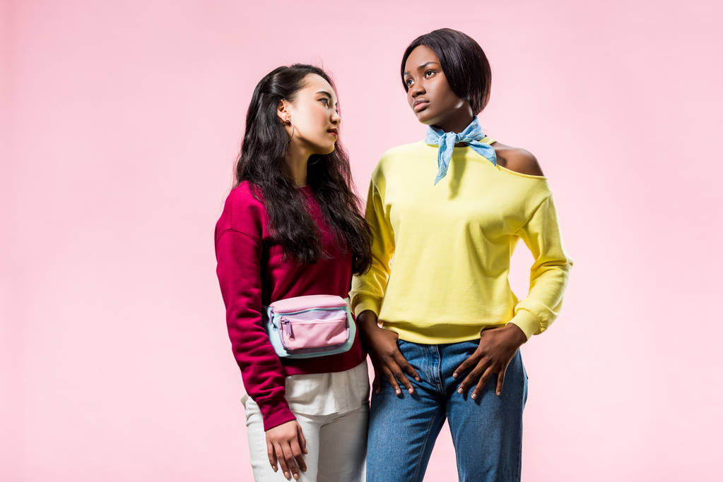vonzó ázsiai és afro-amerikai barátok néz félre elszigetelt rózsaszín  - Fotó, kép