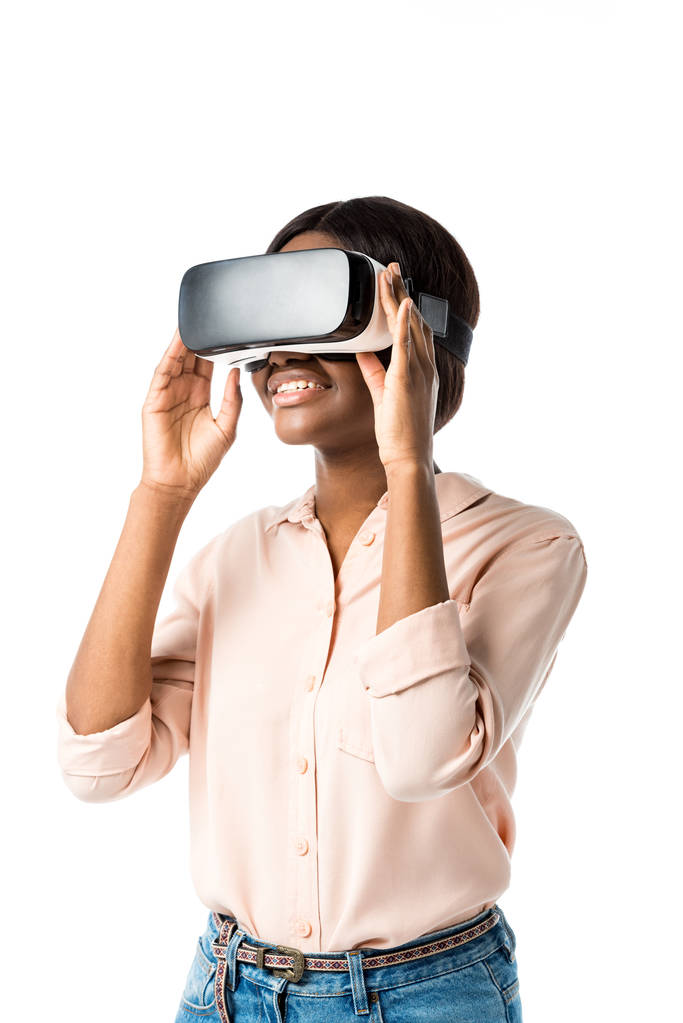 sorridente donna afroamericana in camicia con auricolare realtà virtuale isolato su bianco
  - Foto, immagini