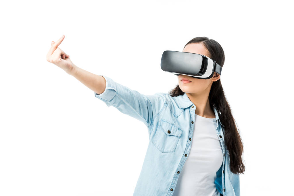 Frau im Jeanshemd mit Virtual-Reality-Headset zeigt Mittelfinger isoliert auf weißem Hintergrund  - Foto, Bild