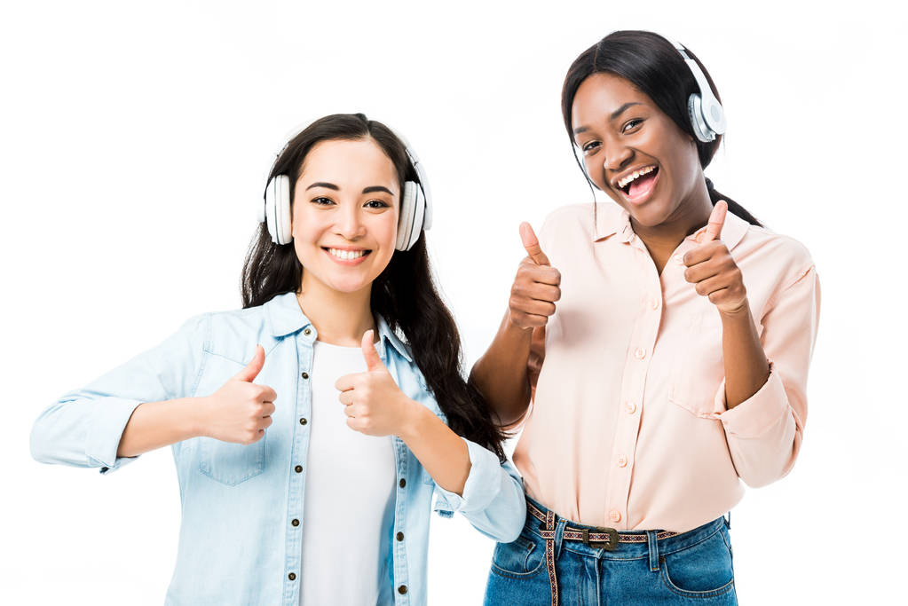 hymyilevä aasialainen ja afrikkalainen amerikkalainen ystäviä kuulokkeet näytetään peukalot ylös eristetty valkoinen
  - Valokuva, kuva