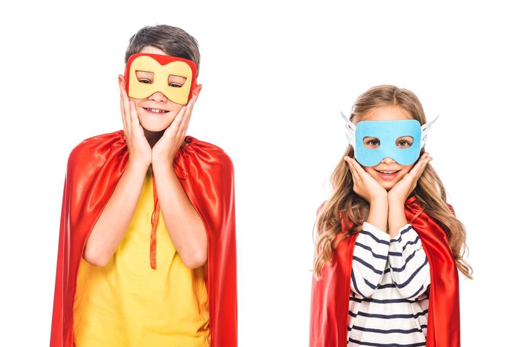 vista frontal de duas crianças sorridentes em máscaras e capas de herói isolado no branco
 - Foto, Imagem