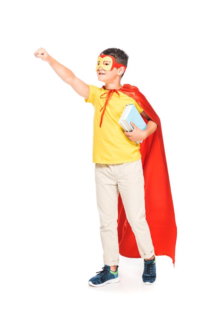 vista completa de niño en máscara y capa de héroe sosteniendo libros aislados en blanco
 - Foto, imagen