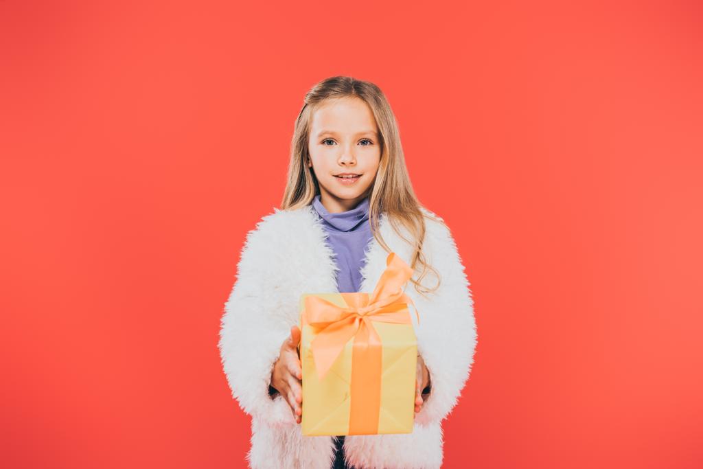 вид ребенка, держащего подарочную коробку, изолированную на красном фоне
 - Фото, изображение