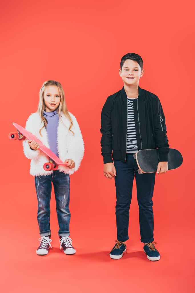 full length view of two kids with skateboards on red - Photo, Image