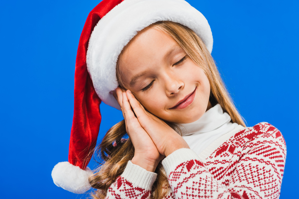 carino bambino in cappello di Babbo Natale e maglione dormire isolato su blu
 - Foto, immagini