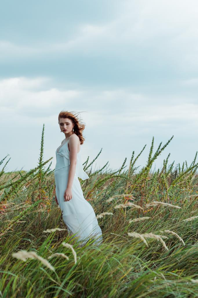 enfoque selectivo de mujer pelirroja en vestido blanco mirando a la cámara
  - Foto, Imagen